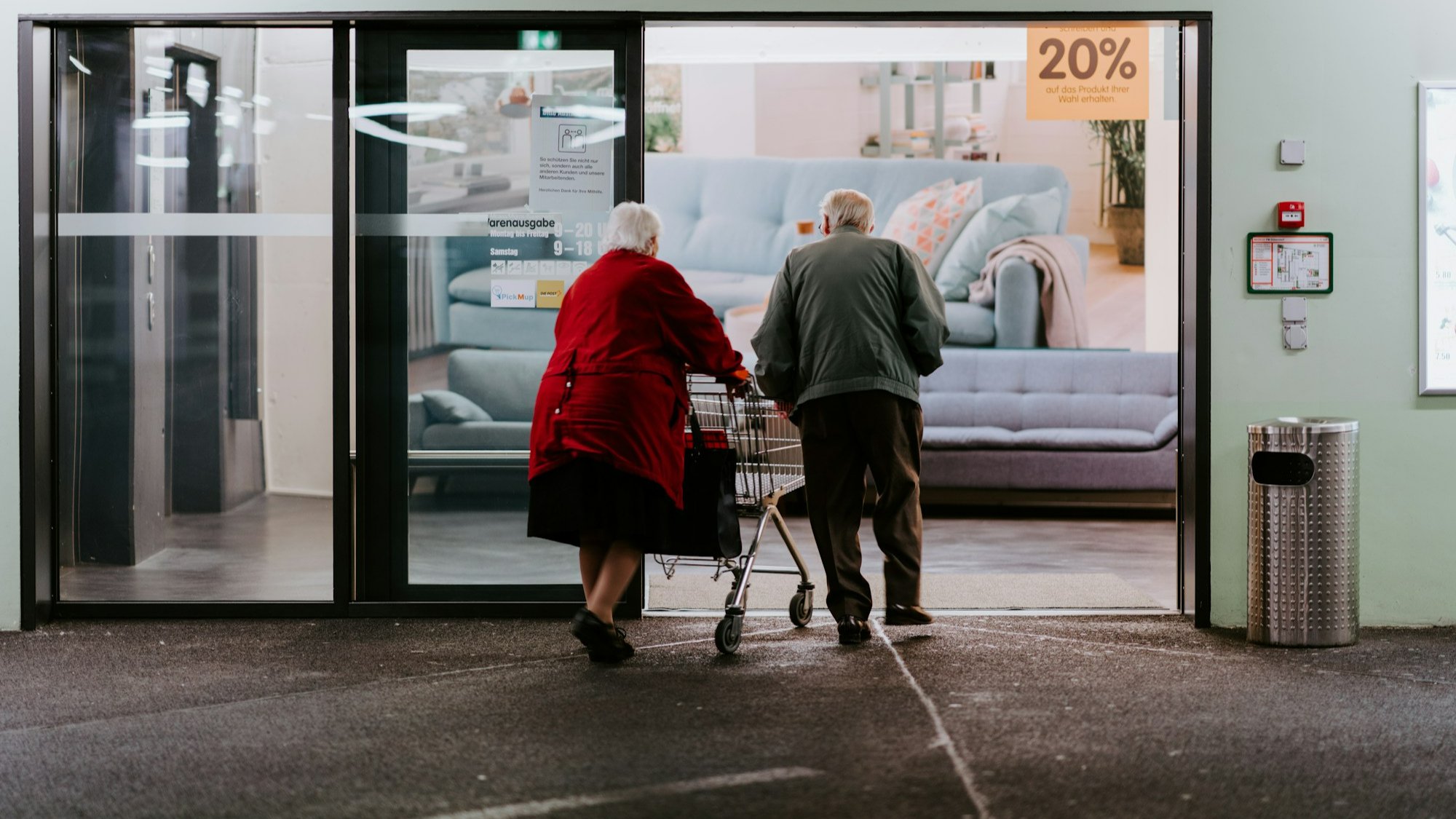 An Elderly couple with a shopping cart entering a retail store underscoring the need for a checklist for aging parents.
