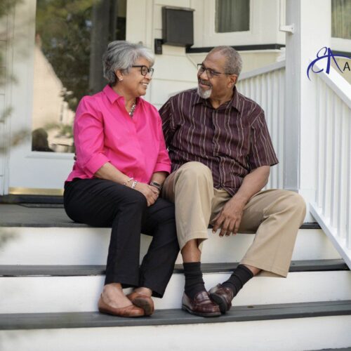 a senior couple sitting on their porch steps