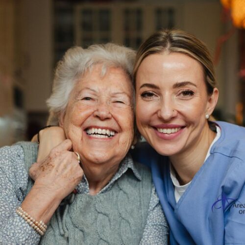 Smiling elderly woman with caregiver